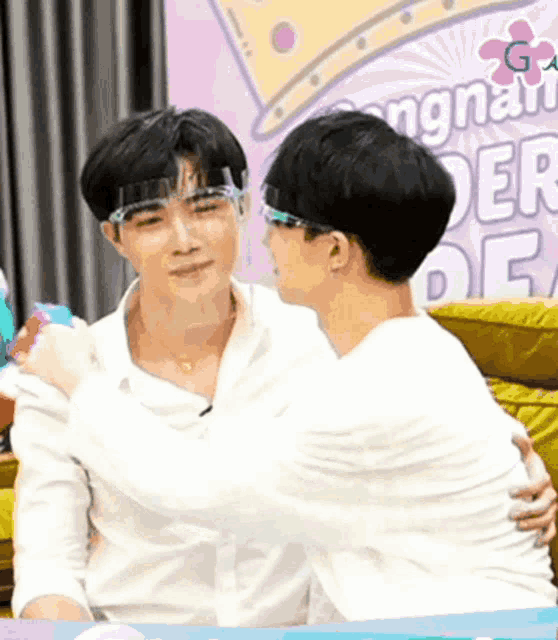 two men are hugging each other in front of a sign that says congratulations