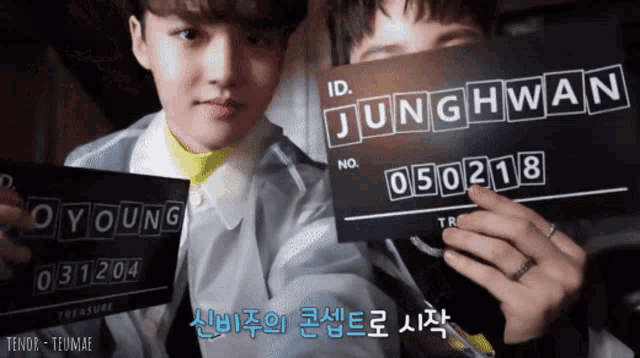 two boys holding up a sign that says junghwan on it
