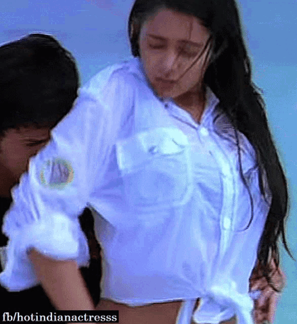 a woman in a white shirt is being kissed by a man on the beach