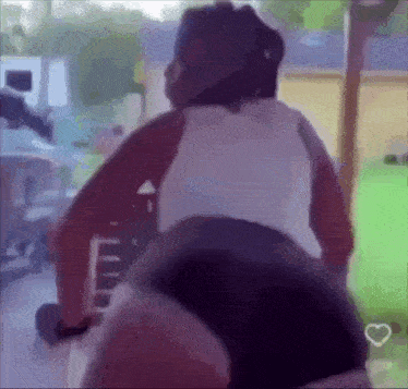 a woman in a white tank top and black shorts is standing on a bicycle .