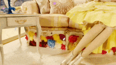 a woman in a yellow dress sits on a couch next to a table