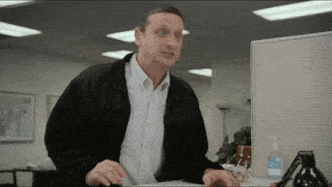 a man standing in front of a cubicle with a hand sanitizer bottle on it
