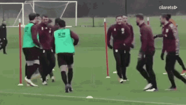 a group of soccer players are practicing on a field with the word clarets in the upper right corner