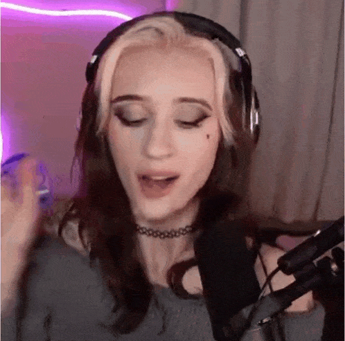 a girl wearing headphones is singing into a microphone .