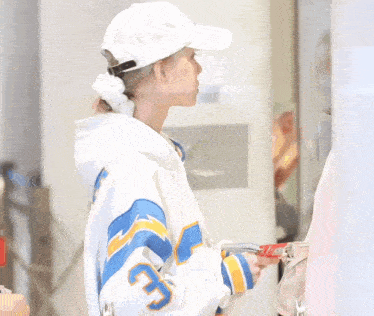 a woman wearing a white hat and a blue and yellow jacket with the number 3 on it