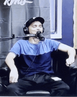 a man wearing headphones is sitting in front of a microphone ..