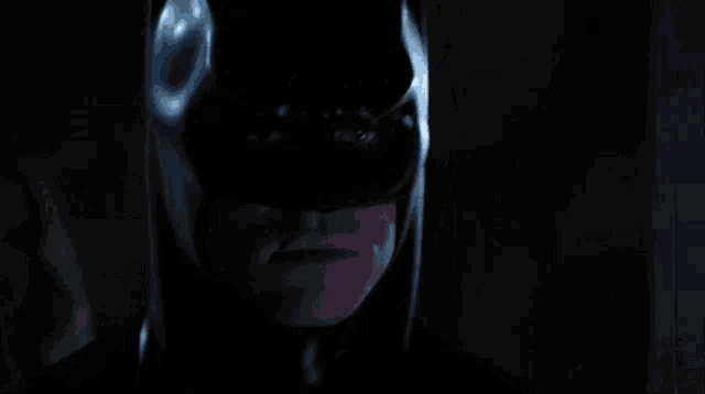 a close up of a man in a batman mask smiling