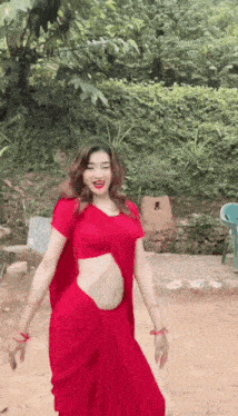 a woman in a red dress is dancing on the ground .