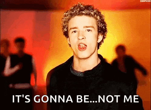 a young man with curly hair is singing in front of a crowd .