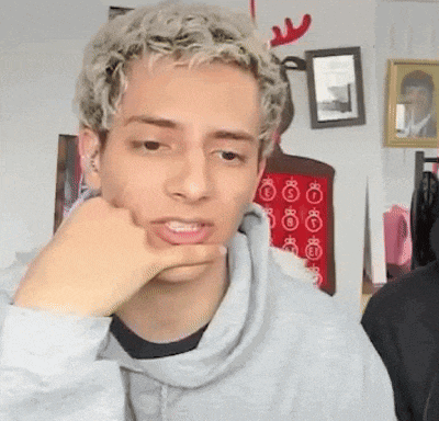 a young man with blonde hair is wearing a gray sweatshirt