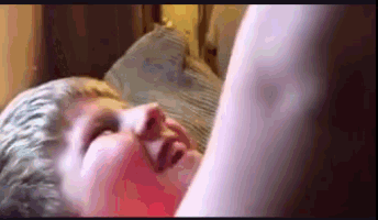 a close up of a person laying in bed with their eyes closed .