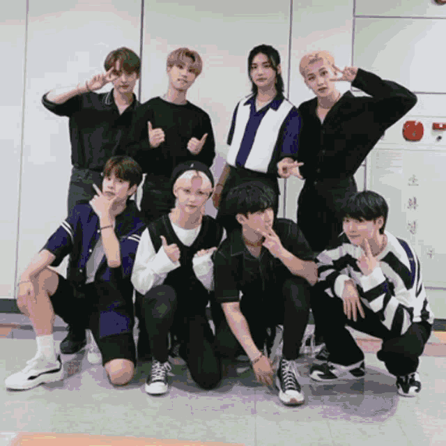a group of young men posing for a picture with one giving the thumbs up sign