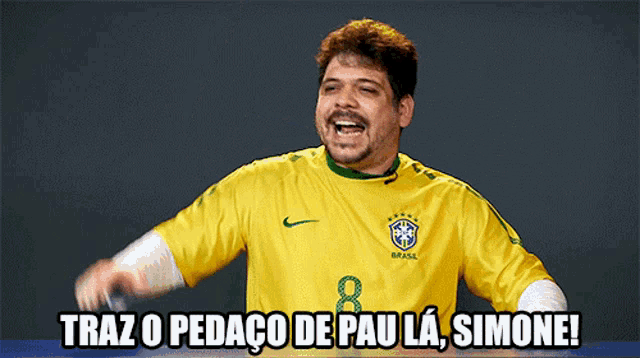 a man wearing a yellow soccer jersey with the number 8 on it says traz o pedaco de pau la simone