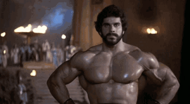 a very muscular man with a beard is standing with his hands on his hips