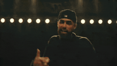 a man with a beard is wearing a hat with the letter m on it