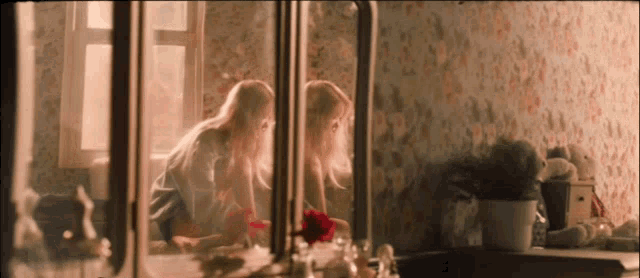 two girls are looking at themselves in the mirror