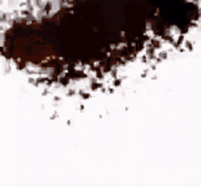 a brown stain on a white surface with a blurred background