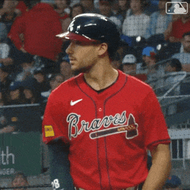 a man holding a baseball bat with the word braves on his jersey