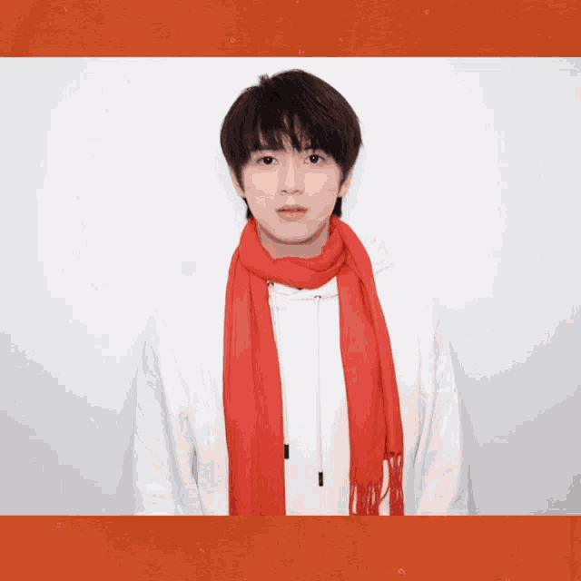 a young man wearing a white sweatshirt and a red scarf around his neck