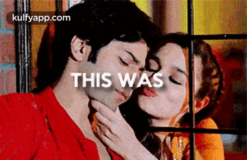 a woman is kissing a man on the cheek and the words `` this was '' are visible in the background .