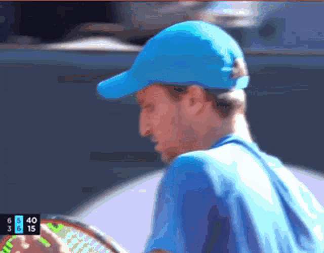 a man wearing a blue hat is playing tennis