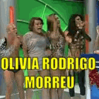 a group of people standing in front of a green screen with olivia rodrigo morreu written in yellow