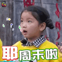 a little girl is wearing a yellow sweater and making a funny face with chinese writing on it .