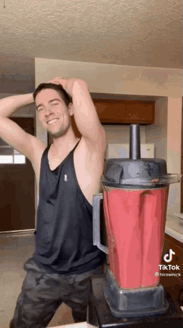 a man is standing next to a blender that says tiktok