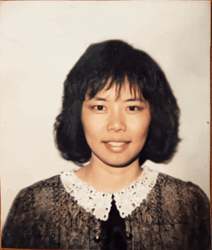 a woman with short black hair and a white collar