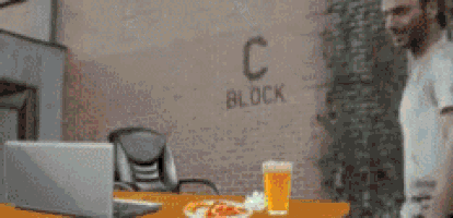 a man is standing in front of a brick wall that says block c