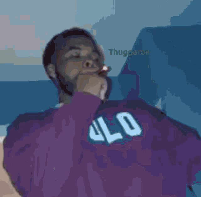 a man wearing a red sweater with the number 40 on it is smoking a cigarette