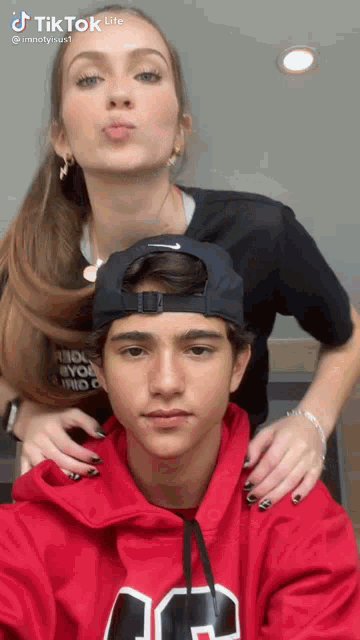 a man and a woman are posing for a picture and the woman is blowing a kiss
