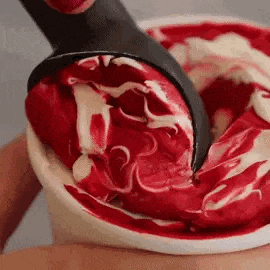 a close up of a person scooping ice cream out of a cup .