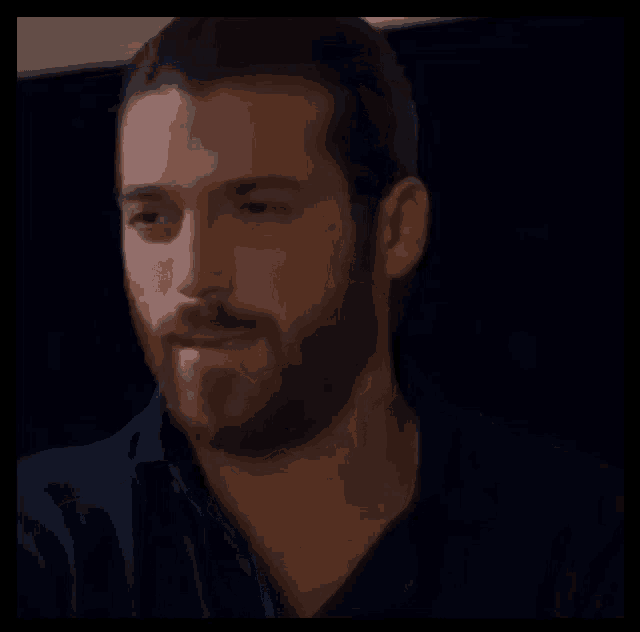 a man with a beard wearing a blue shirt