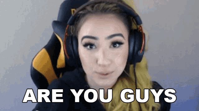 a woman wearing headphones says " are you guys " while sitting in a chair