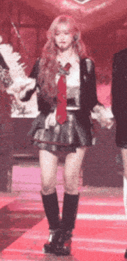 a girl in a school uniform is dancing on a red carpet .