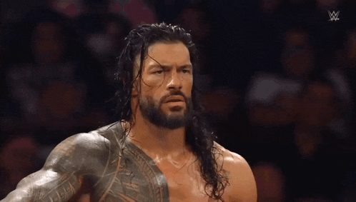 a man with long hair and a beard is standing in front of a crowd