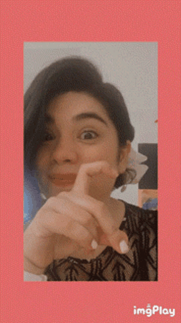 a woman is making a funny face with her hand on her chin in front of a pink background that says imgplay on it