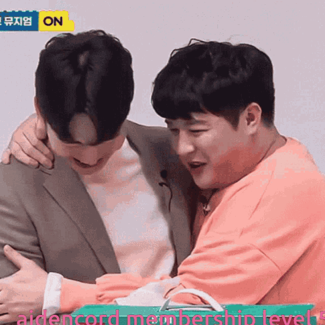 a man in a suit is hugging another man in a pink shirt with the words aidencord membership level 5 on the bottom
