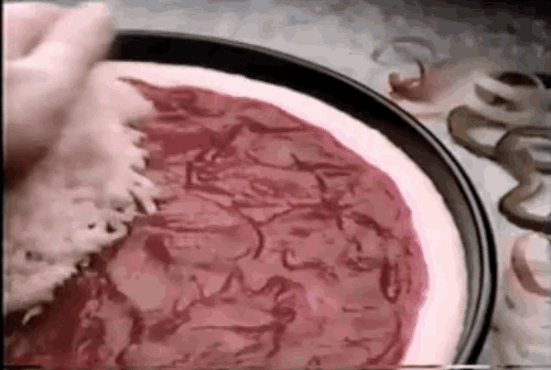 a close up of a pizza with red sauce and cheese on it