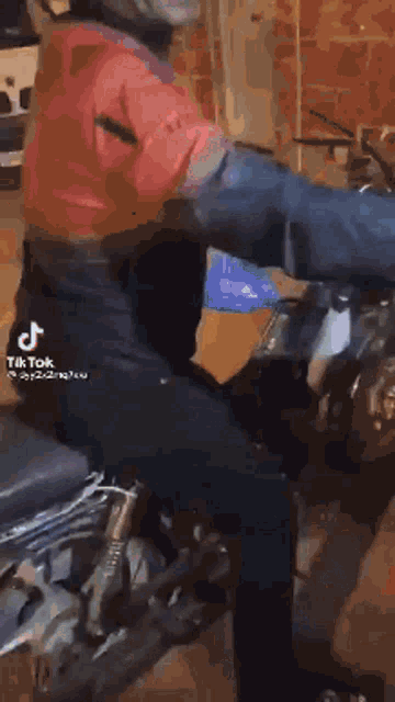 a man in a red shirt is riding a motorcycle in a tiktok video .