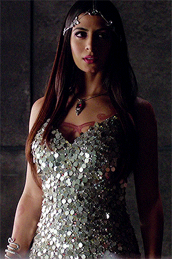 a woman in a silver sequined dress with a necklace on her neck