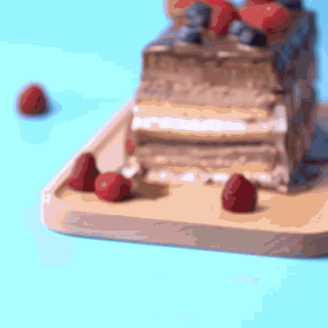 a slice of cake with strawberries and blueberries on top of it