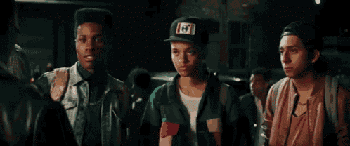 three young men are standing next to each other in a crowd .