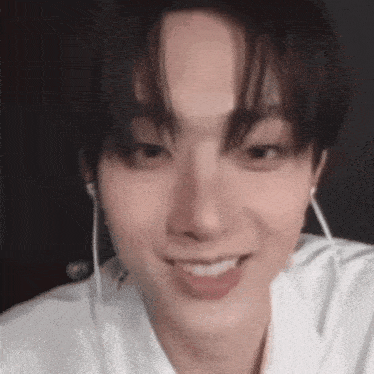 a close up of a person wearing earphones and smiling .