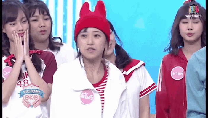 a girl wearing a red hat with bunny ears has a sticker on her shirt that says victory