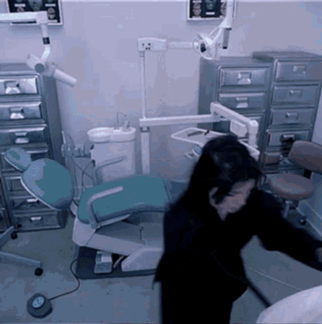 a woman stands in front of a dental chair