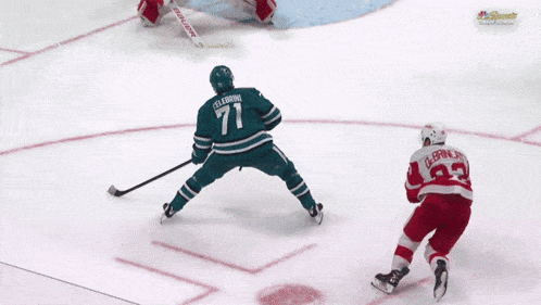 a hockey player with the number 71 on his jersey stands on the ice