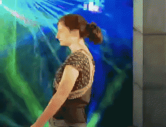 a pixelated image of a woman standing in front of a large aquarium