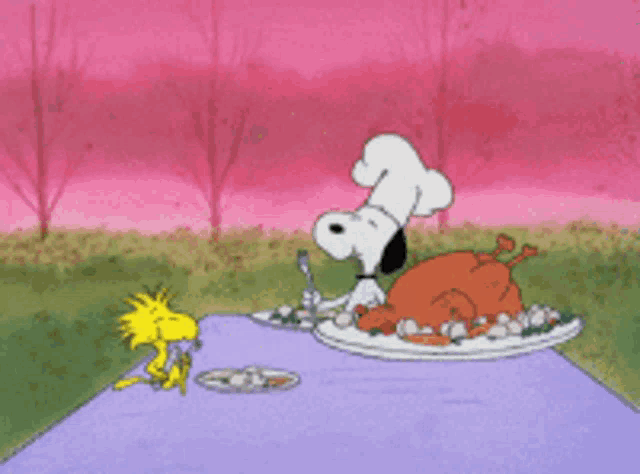 a cartoon of snoopy and woodstock sitting at a table with a plate of food